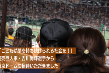 東京ドームの観客席から打席に立つ吉川選手を見守る親子の写真。テキスト「こどもが夢を持ち続けられる社会を！ 読売巨人軍・吉川尚輝選手から東京ドームに招待いただきました」
