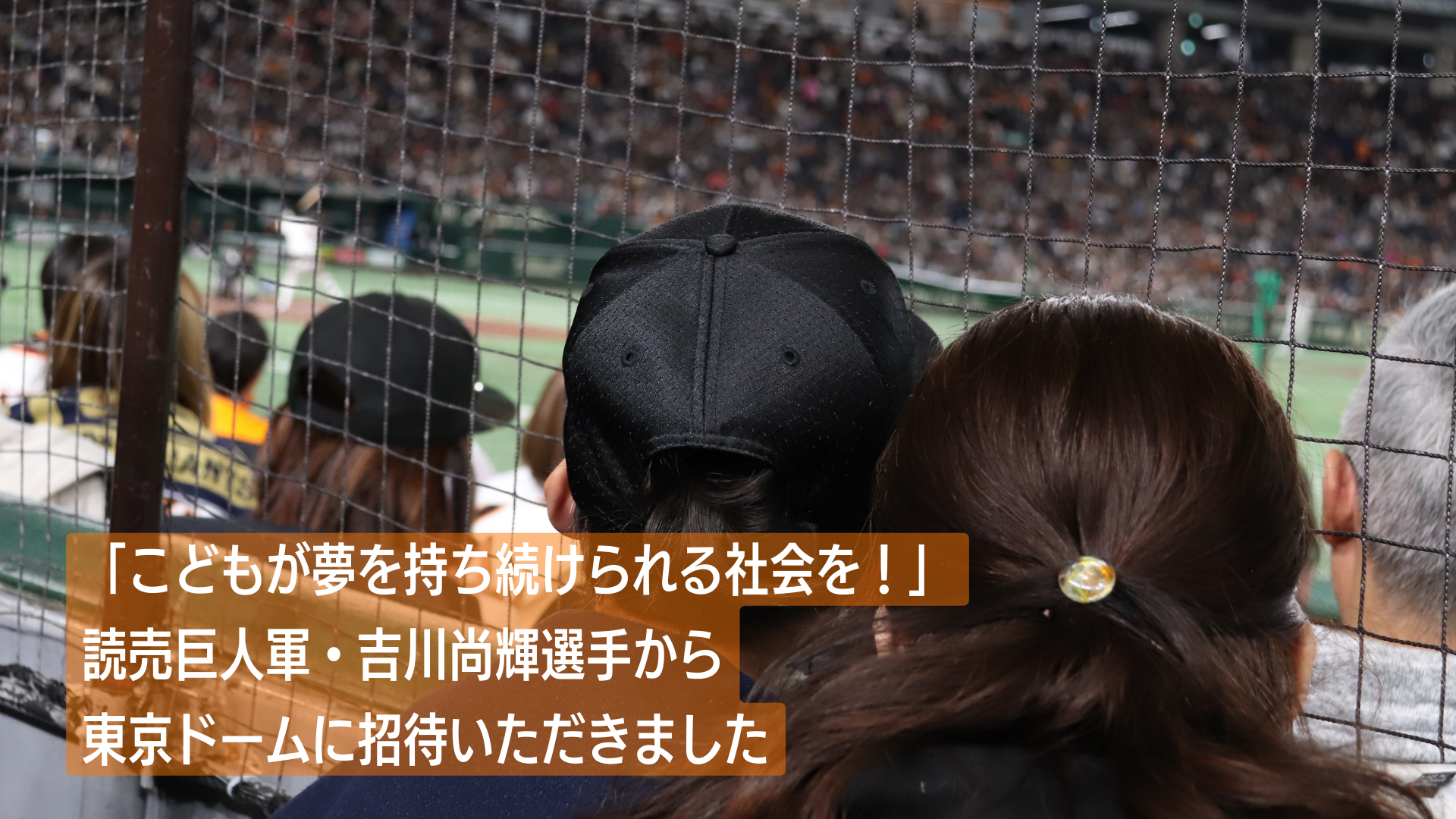 東京ドームの観客席から打席に立つ吉川選手を見守る親子の写真。テキスト「こどもが夢を持ち続けられる社会を！ 読売巨人軍・吉川尚輝選手から東京ドームに招待いただきました」