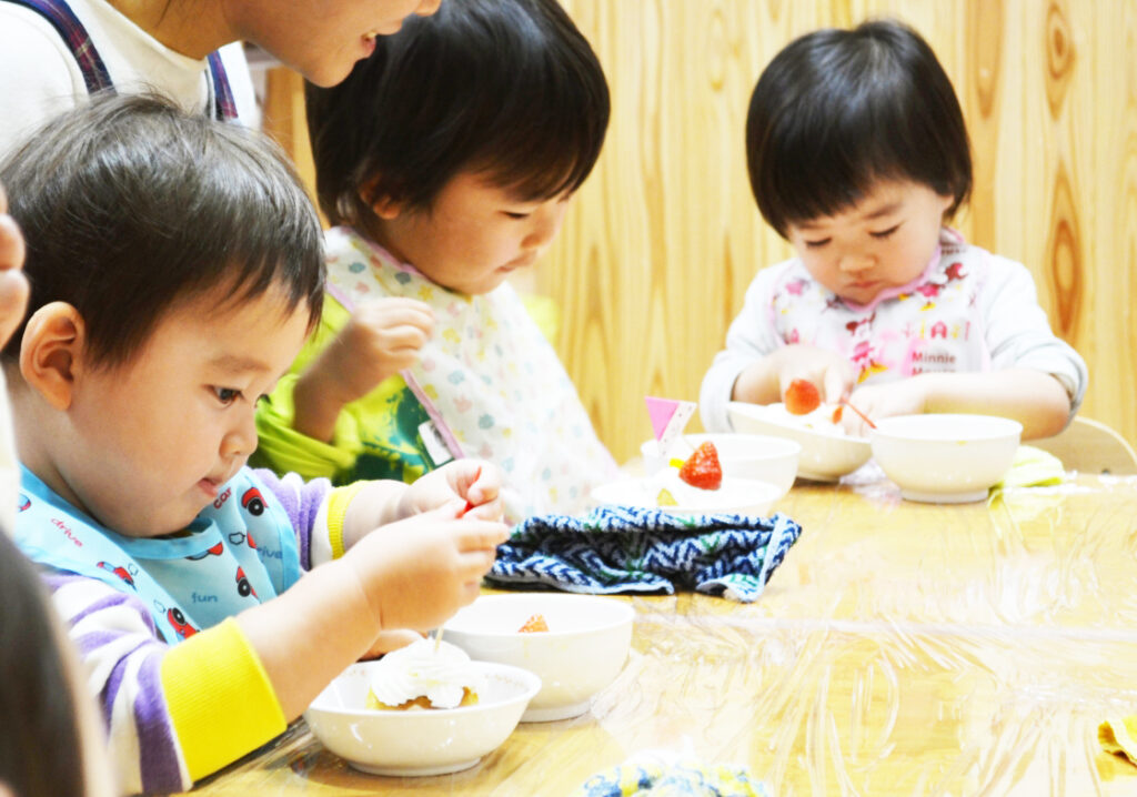 園児がカップケーキの盛り付けをする様子