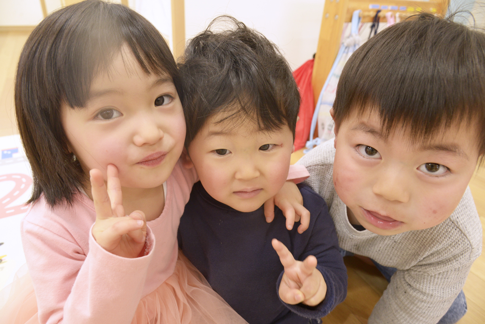 仲良し友達3人でピースサインをしている写真