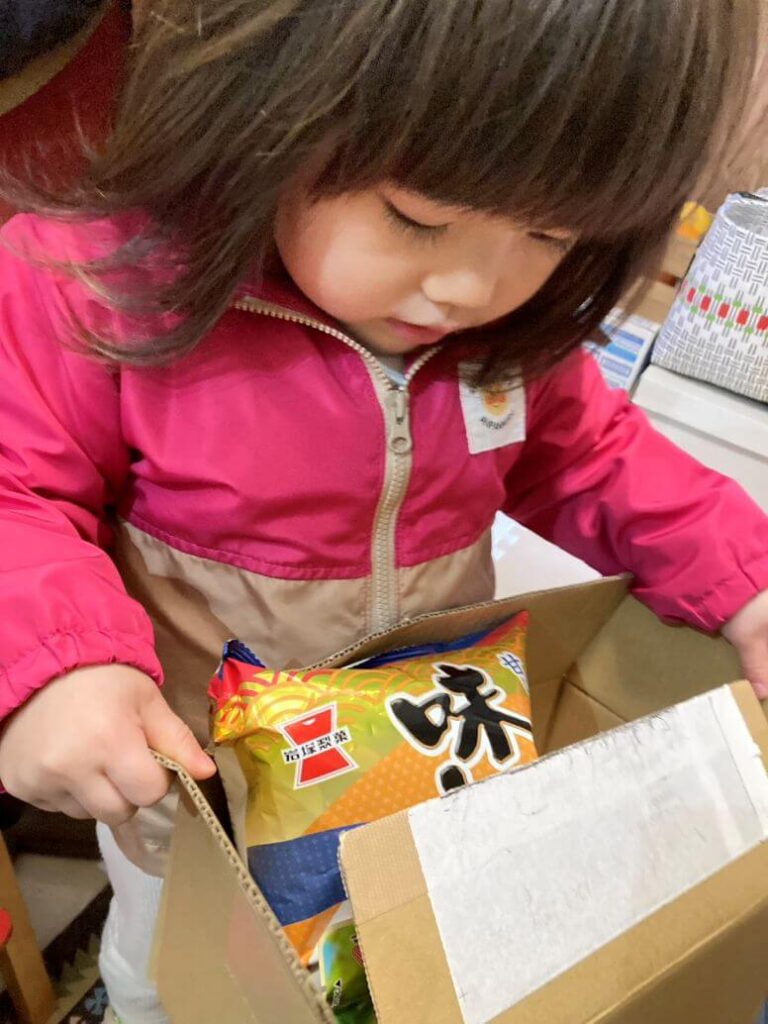 届いた物資をみつめるお子さん