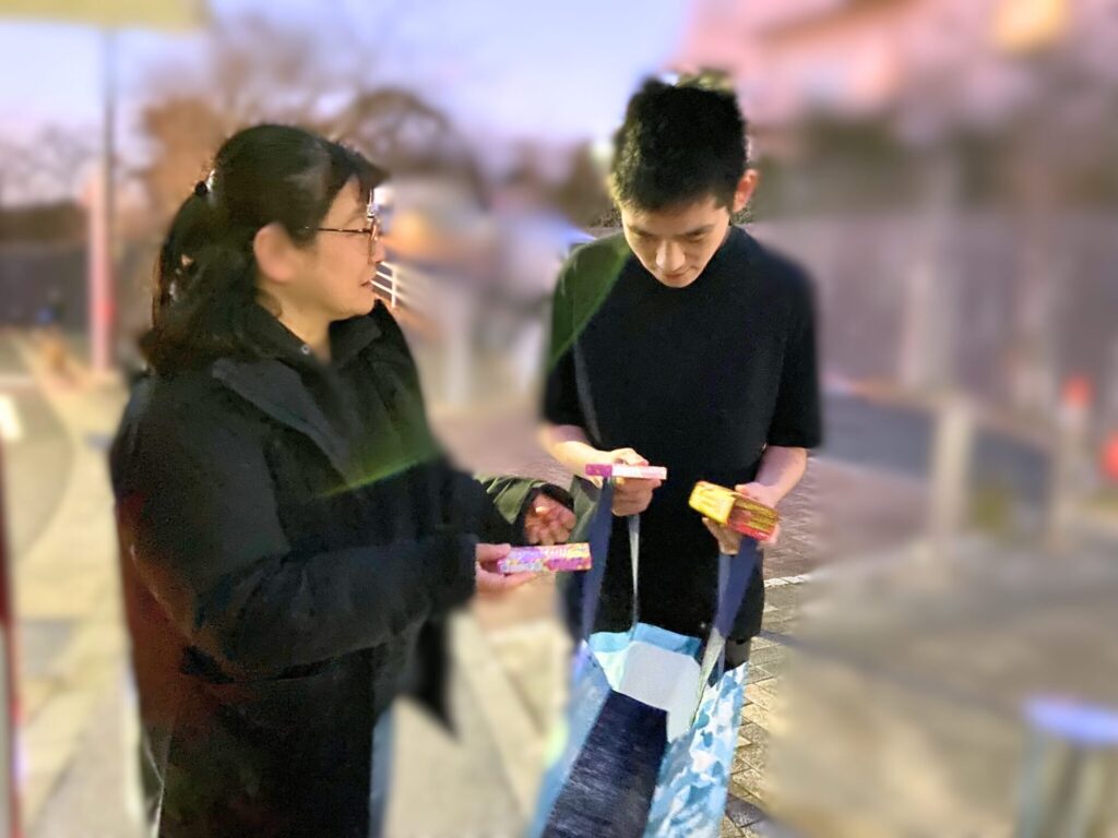 こども宅食でお子さんにお菓子を手渡す佐藤さん