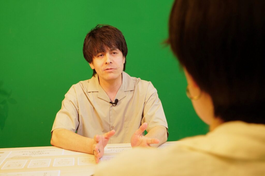 インタビューに答えるサントリーのなかじまさんの写真